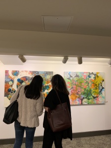 Two women viewing a painting