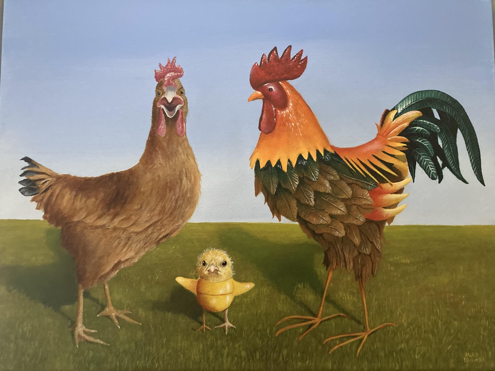 A chicken, baby chick, and a rooster standing in the grass with a blue sky background