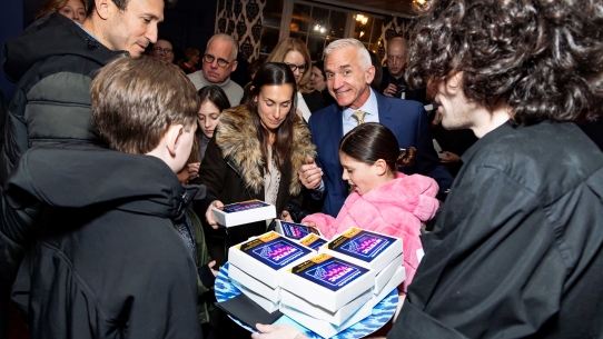 Mystic Pizza Opening Night - guests surrounding a tray of small pizza boxes